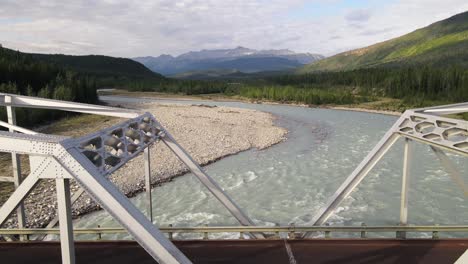 White-bridge-crossing-the-turquoises-waters-of-Toad-River-in-northern-British-Columbia,-Canada