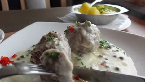 Eating-meatballs-with-white-sauce