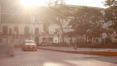 A-taxi-navigating-around-the-Independence-Square-approaching-the-entrance-of-the-Central-Hotel-Panama,-collecting-a-group-of-tourist-guests-on-a-beautiful-early-morning,-Casco-Viejo,-Panama-City
