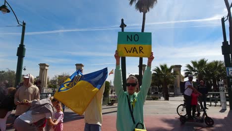 Frauen-Halten-Bei-Einer-Friedenskundgebung-Ein-„Kein-Krieg“-Schild-Und-Eine-Ukrainische-Flagge-Hoch