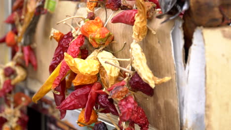 Dried-red-and-orange-peppers-hanging-beside-the-wall