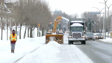 Industrial-snow-cleaning-equipment-plowing-snow-to-back-of-Mack-truck