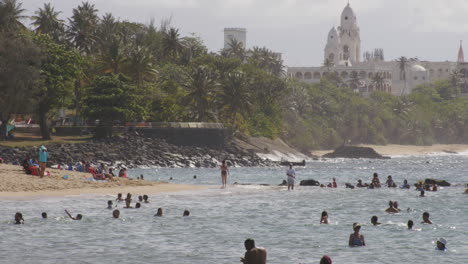 Beachgoers-relaxing-in-sunshine-and-swimming-in-sea-at-Belneario-beach,-San-Juan,-Puerto-Rico