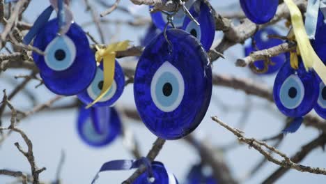 Close-up-shot-of-evil-eye-beads-tied-to-tree-branches