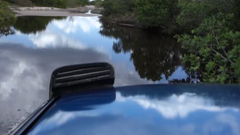 offroad-car-going-through-a-big-puddle,-almost-submerging-in-it