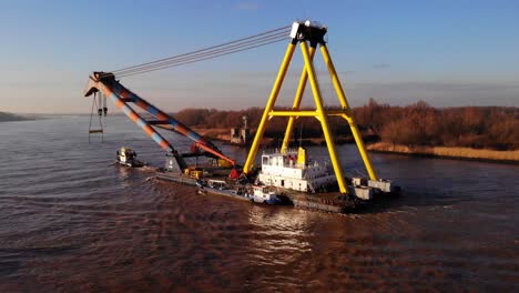 Aerial-View-Of-Hebo-9-Lift-Floating-Crane-Being-Pulling-By-Tug-Boat-Along-Oude-Maas