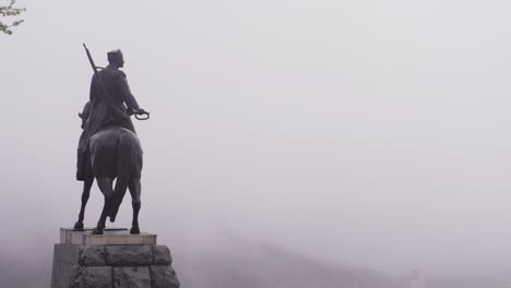 4K-footage-of-a-monument-on-top-of-the-mountain-Stara-Planina-in-Vratsa,-Bulgaria,-while-a-deep-fog-covers-the-town