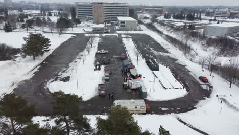 Aerial-Towards-Snow-Covered-Car-Parking-Lot-With-Food-Truck-For-Freedom-Convoy-In-Ottawa