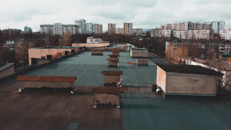 Drone-flying-over-the-roof-of-two-buildings-in-Chisináu,-Moldova