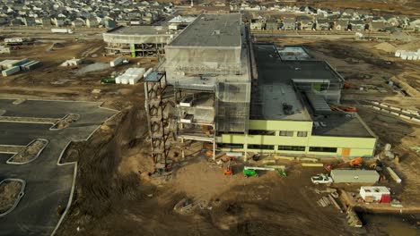 Aerial-view-of-the-construction-site-for-the-Primary-Children's-Hospital-in-Lehi,-Utah-then-descent-to-view-the-billboard-announcement