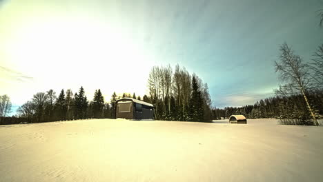 Scenic-timelapse-shot-of-wooden-vacation-cabins-covered-with-thick-layer-of-snow-during-winter-season-with-trees-forest-in-the-background
