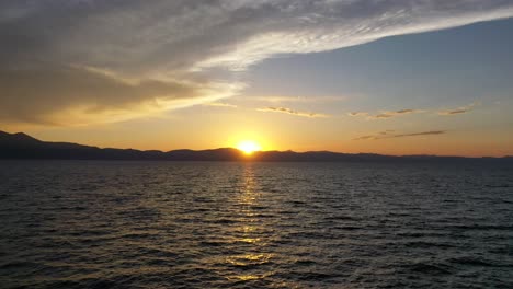 Flug-über-Ruhiges-Meer-Mit-Wunderschönem-Sonnenuntergang-Im-Hintergrund