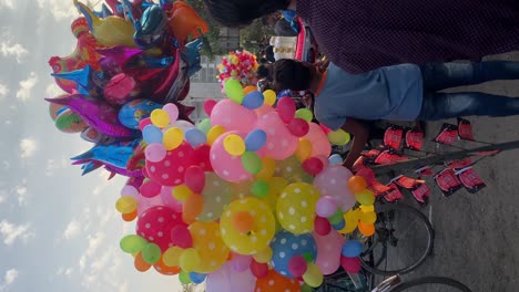 Eine-Vertikale-60fps-Aufnahme-Eines-Kindes,-Das-Luftballons-Verkauft