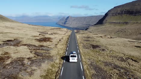 White-campervan-driving-at-an-scenic-road-at-Feroe-Islands