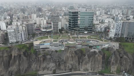 Aerial-flight-to-shopping-mall-perched-on-cliff-top-in-Miraflores-Peru