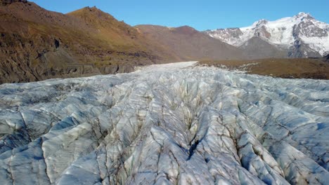 Dirty-glacier-surface-with-deep-cracks