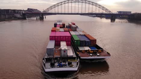 Aerial-View-Of-Excelsior-Cargo-Ship-Paired-With-Barge-Transporting-Cargo-Containers-On-River-Noord-With-Brug-over-de-Noord-In-Background