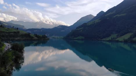 Fishing-boat-on-serene-Lungernersee-lake-in-Swiss-alps-mountains,aerial-panorama