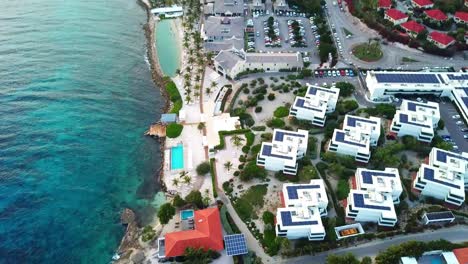 Tilt-up-aerial-view-of-the-mansions-and-housing-complexes-of-Jan-Thiel-Beach,-Curacao,-Dutch-Caribbean-island