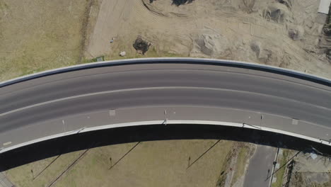 Aerial-perspective-of-silver-car-moving-from-right-to-left-hand-side-of-frame-over-new-bridge