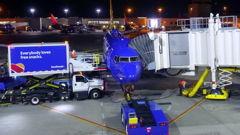 Timelapse-of-Southwest-Airlines-plane-docking-with-air-traffic-control-unloading-luggage-and-filling-up-snacks-by-ground-crew-in-hangar-terminal-at-the-airport-1