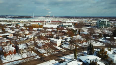 Winter-aerial-view-over-snow-covered-homes-and-buildings-in-Oakville,-Ontario