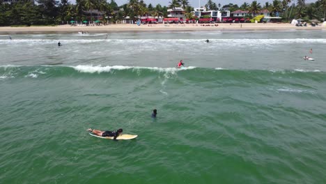 Kamerafahrt-Eines-Mädchens,-Das-Am-Strand-Von-Mirissa,-Sri-Lanka,-Auf-Einer-Flachen-Welle-Surft