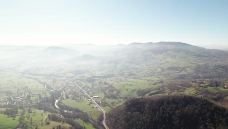 Giant-forest-with-in-the-background-the-partly-in-fog-covered-green-valley-between-the-mountains-of-the-Spanish-province-Cantabria-on-a-early-sunny-morning