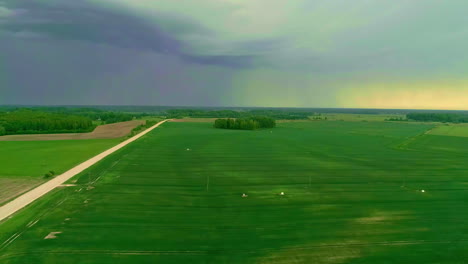 Aerial-drone-shot-from-right-to-left-of-rural-pathway-passing-through-green-field