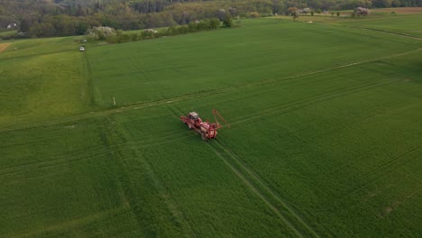 Luftaufnahmen-Eines-Traktors,-Der-Seine-Sprinkleranlage-Auf-Einer-Riesigen-Grünen-Wiese-Entfaltet