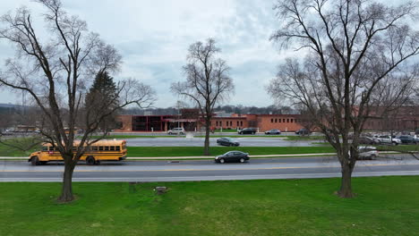 School-bus-traffic-on-road-pass-by-school-building