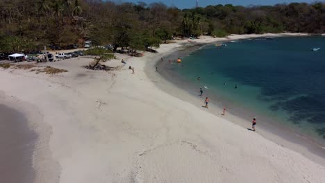 San-Juanillo-White-Sand-Beach-in-Costa-Rica,-People-Swim-and-Sunbath-on-Seaside