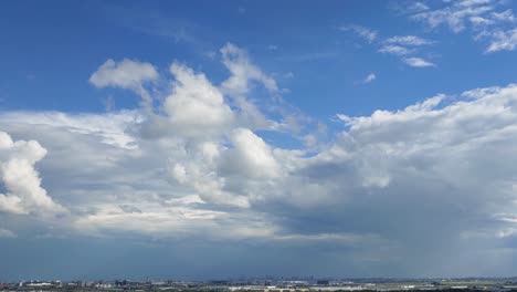 Timelapse-of-cumulus-floating-clouds-against-blue-sky-with-miniature-city-view