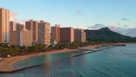 Crowded-Beach-with-People-Swimming-inside-Breakwall-And-Diamond-Head-Tuff-Cone-Overlooking-Kuhio-Beach-In-Waikiki,-Hawaii