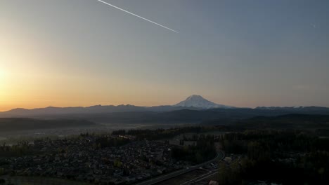 Luftaufnahme-Eines-Jetstreams,-Der-Bei-Sonnenaufgang-über-Den-Mount-Rainier-Fliegt