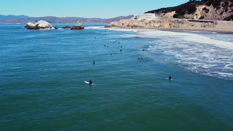 Surfers-Sitting-On-Surfboard-Waiting-For-Perfect-Wave-To-Surf-In-San-Francisco-Ocean-Beach,-California,-USA
