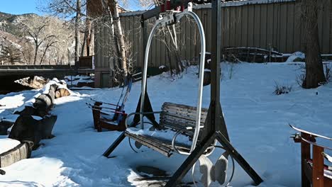Ski-lift-chair-converted-to-a-park-bench-with-snow-on-it-during-the-winter,-handheld