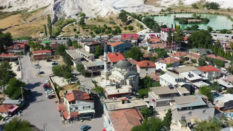 aerial-top-down-view-of-a-small-town-with-residential-buildings-in-Pamukkale-Turkey-and-mineral-rich-mountain-hills-in-the-distance