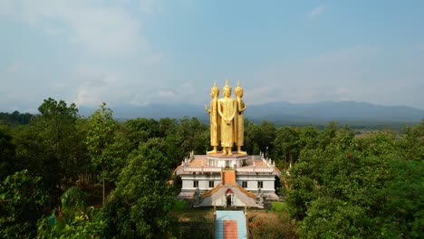 Luftdrohne-Des-Goldenen-Wat-Doi-Sapanyoo-Mit-Einer-Großen-Treppe,-Die-Zu-Vier-Einzigartigen-Buddha-Statuen-Führt,-Die-Sich-In-Den-Berghügeln-Von-Chiang-Mai,-Thailand,-Umgeben-Von-Einem-Wald,-An-Einem-Sonnigen-Sommertag-Befinden