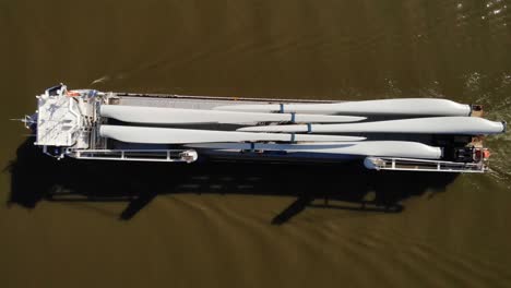 Aerial-Birds-Eye-View-Over-Symphony-Provider-Cargo-Ship-Transporting-Wind-Turbine-Propeller-Blades-Along-Oude-Maas