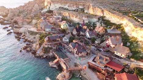 Wooden-film-set-village-of-Popeye-on-Malta-island-coastline,-aerial-drone-view