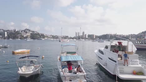 Boats-anchored-in-port-at-Acapulco-shore,-pan-left
