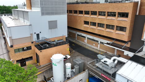 Aerial-view-of-ambulance-driving-into-hospital-parking-area