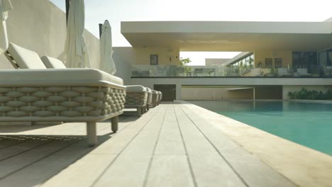 Low-angle-view-of-luxury-tropical-villa-with-pool,-Sun-Loungers-and-Outdoor-Seating