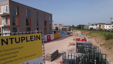 Aerial-approach-of-construction-site-information-banner-of-Ubuntuplein-in-urban-development-real-estate-investment-project-in-new-Noorderhaven-neighbourhood-showing-the-garden-construction
