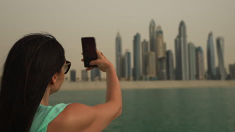 Mädchen-Fotografiert-Die-Skyline-Von-Dubai-Vom-Boot-Aus