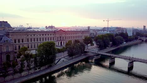 Morning-aerial-footage-of-Louvre-museum-and-Pont-des-Arts-bridge-over-Seine-river