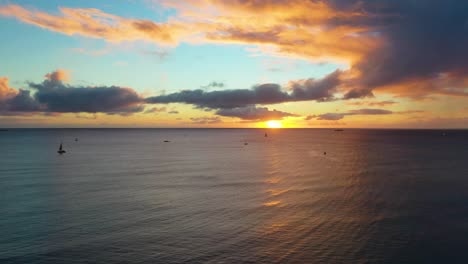 Drone-View-of-Hawaiin-Ocean-Sunrise-with-Boats-Sailing-Over-Waikiki-Beach-In-Honolulu