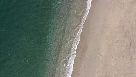 Waves-Crashing-on-Beach-with-People-Swimming-and-Standing,-Aerial-View