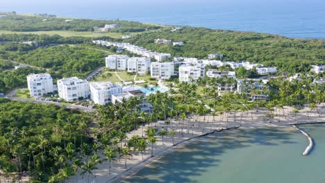 Luftüberführung-Tropisches-Playa-Nueva-Romana-Mit-Sandstrand-Und-Modernen-Luxusapartments-Im-Hintergrund